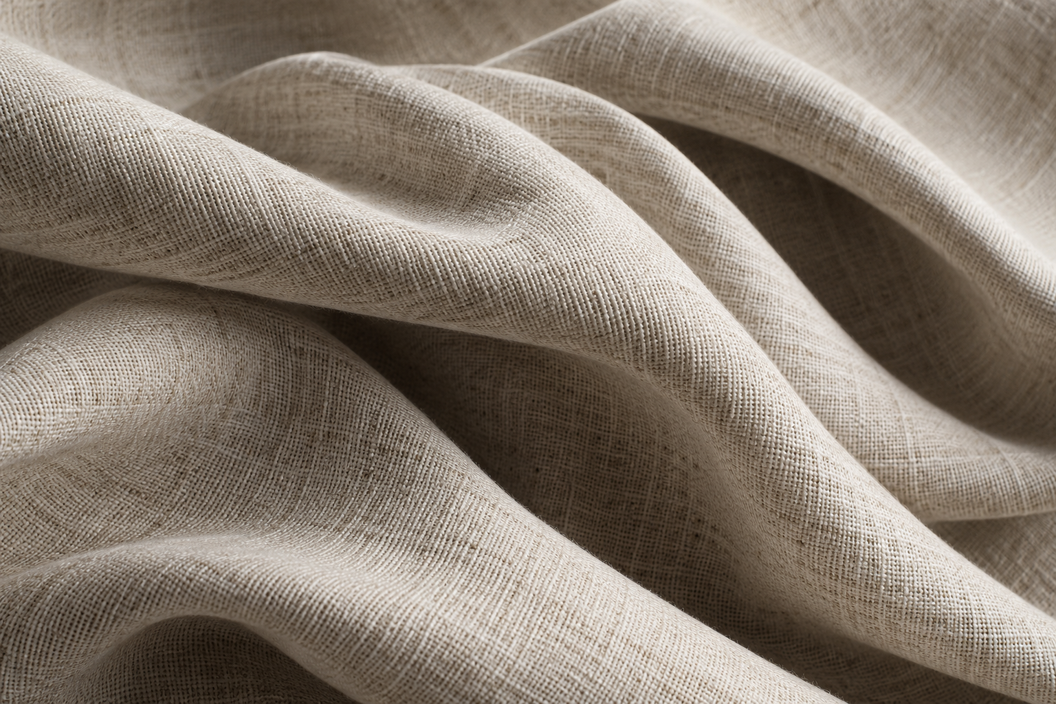 An illustrative close-up of undyed woven fabric in soft folds